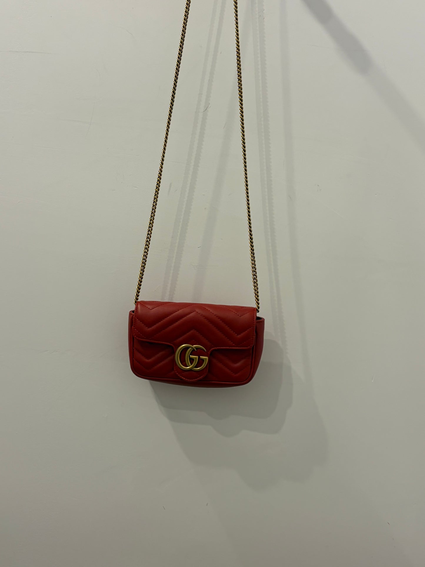 Gucci GG Marmont Super Mini Chain Shoulder Bag in Hibiscus Red Matelassé Leather with antique gold hardware
